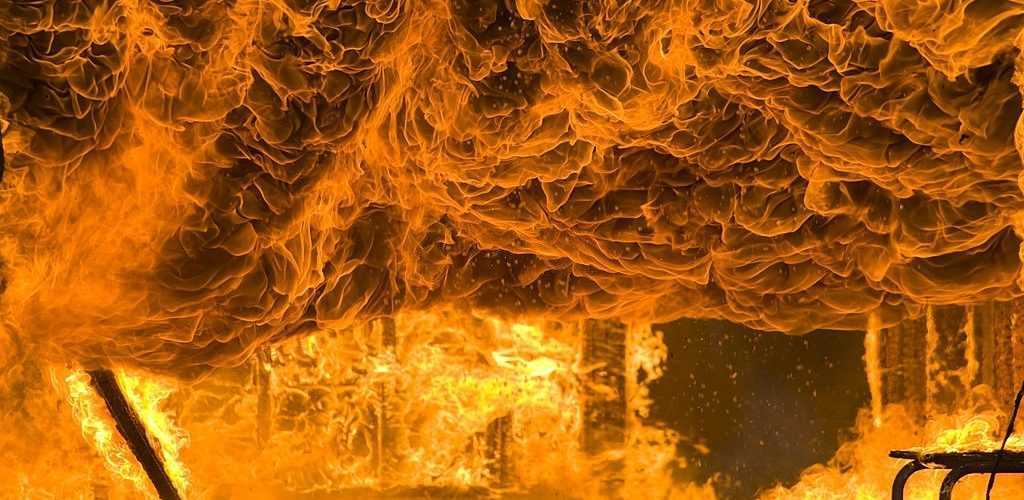 Fire and Intense Flames Burns Home to the Ground. Flashpoint reached in large destructive fire burns a home to the ground. Image looking toward what was once an attached garage. Fire is reaching flashpoint and a raw force of nature. Converted from 14-bit RAW file. sRGB color space.